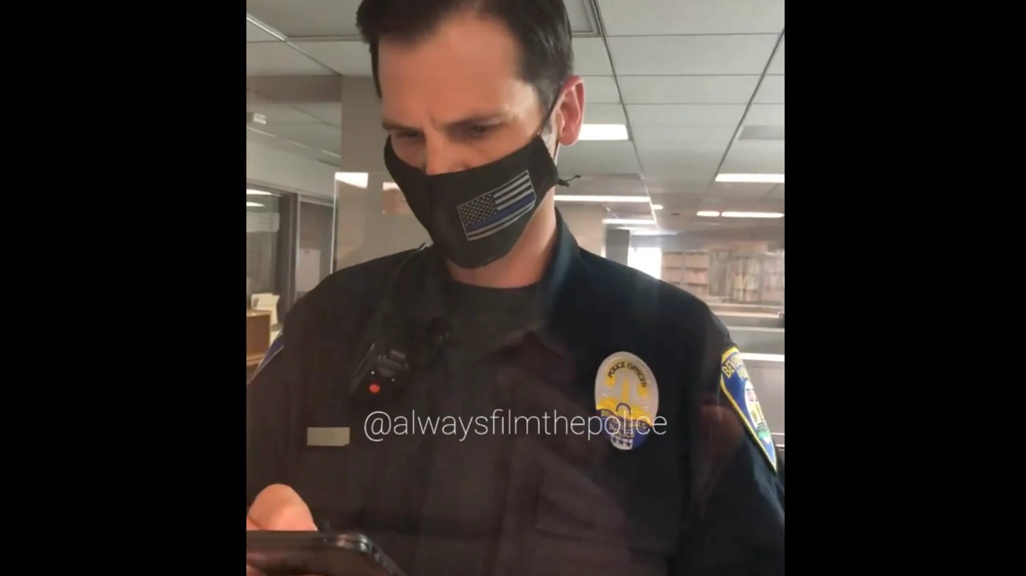 Poliziotto di Beverly Hills con smartphone in mano